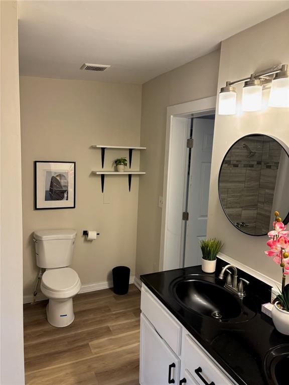 bathroom featuring vanity, hardwood / wood-style flooring, and toilet