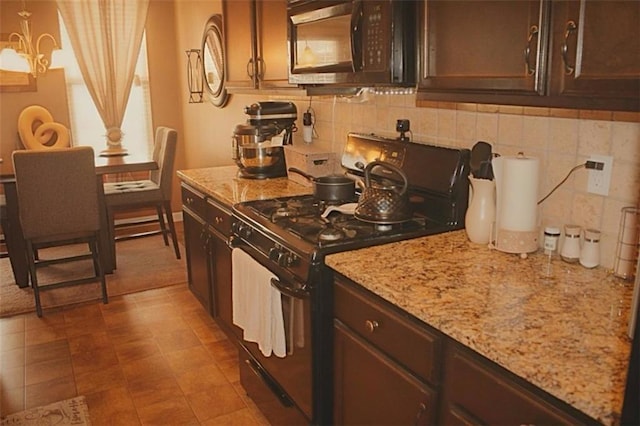 kitchen featuring pendant lighting, dark brown cabinetry, and black appliances