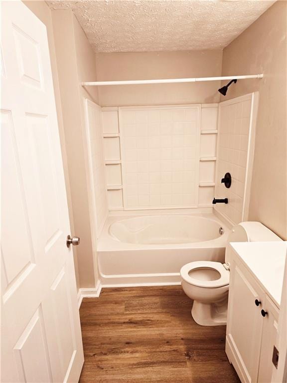 full bathroom featuring vanity, hardwood / wood-style flooring, toilet, and a textured ceiling