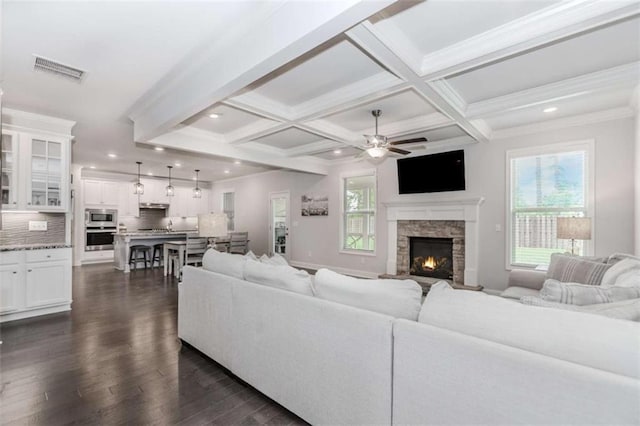 72 Whistling Dr, Jefferson, GA 30549 - living room with a ceiling fan, healthy amount of natural light, dark wood finished floors, beamed ceiling, and a fireplace