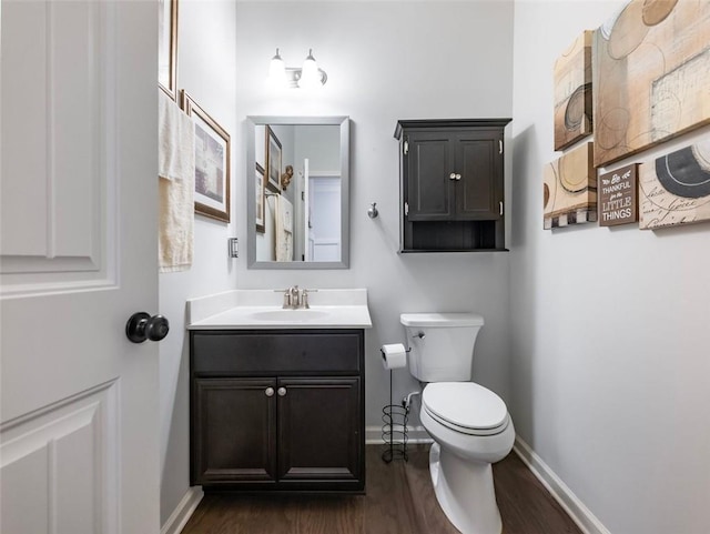 bathroom with vanity, wood-type flooring, and toilet