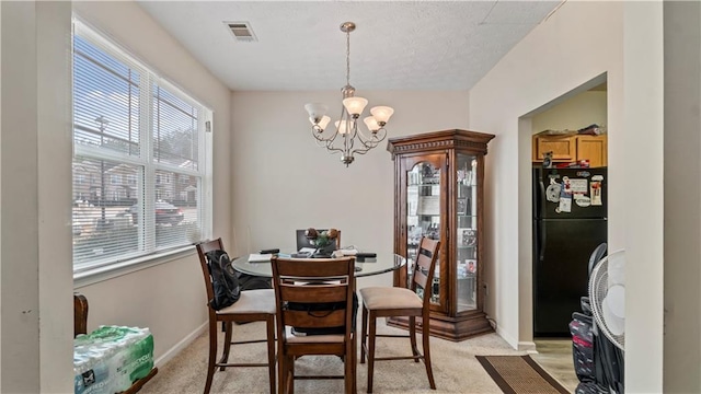 dining area featuring light colored carpet, visible vents, baseboards, and an inviting chandelier