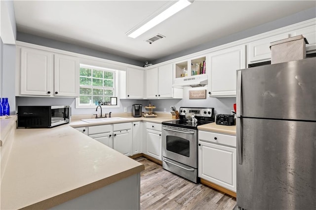 115 Donna Dr, Dawsonville, GA 30534 - kitchen featuring stainless steel appliances, under cabinet range hood, light wood finished floors, and white cabinets