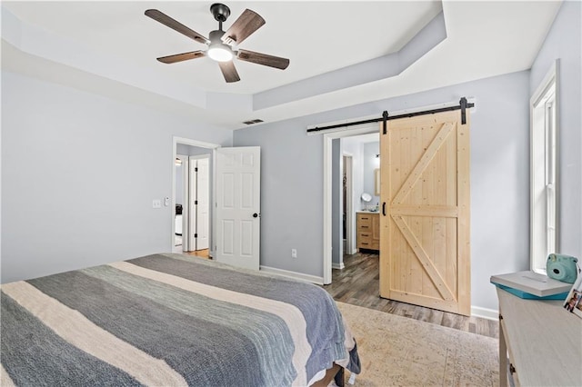 115 Donna Dr, Dawsonville, GA 30534 - bedroom with a raised ceiling, a barn door, wood finished floors, and a ceiling fan