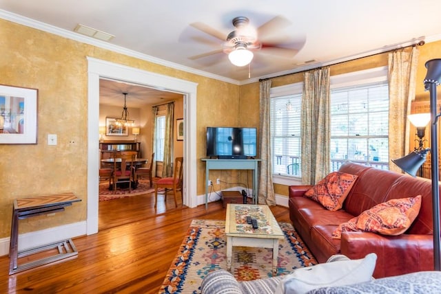 living room featuring ornamental molding, ceiling fan, a fireplace, and hardwood / wood-style floors