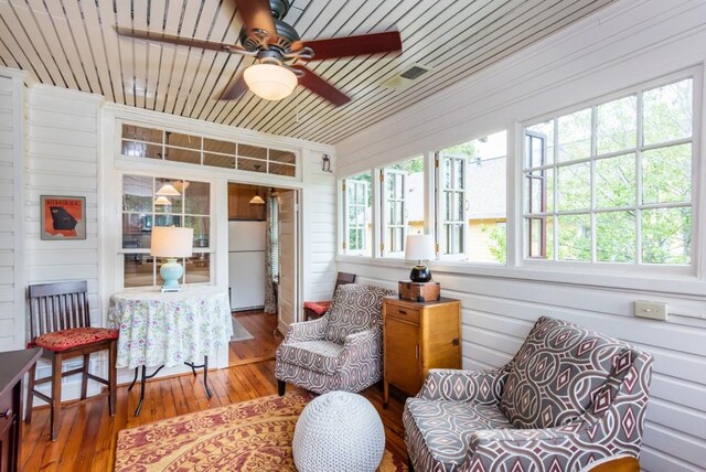 sunroom featuring wooden ceiling, ceiling fan, and plenty of natural light