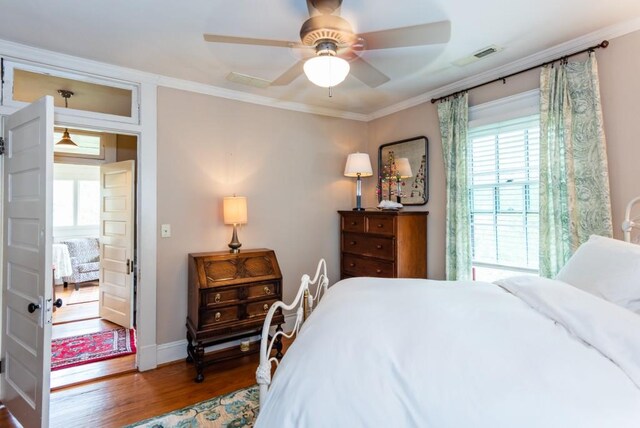 bedroom featuring ceiling fan, hardwood / wood-style flooring, and crown molding