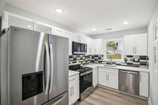 kitchen with stainless steel appliances, sink, and white cabinets