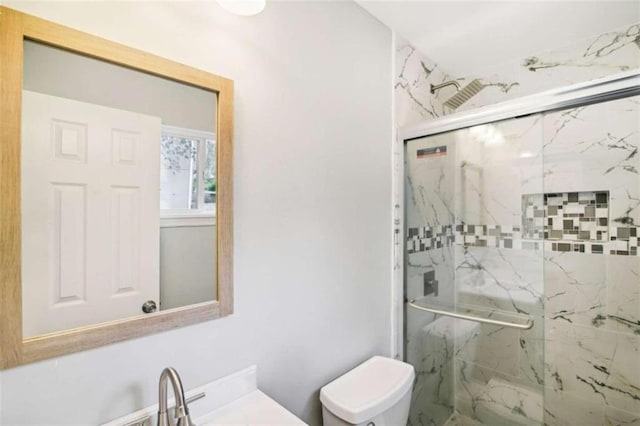 bathroom with toilet, an enclosed shower, and sink