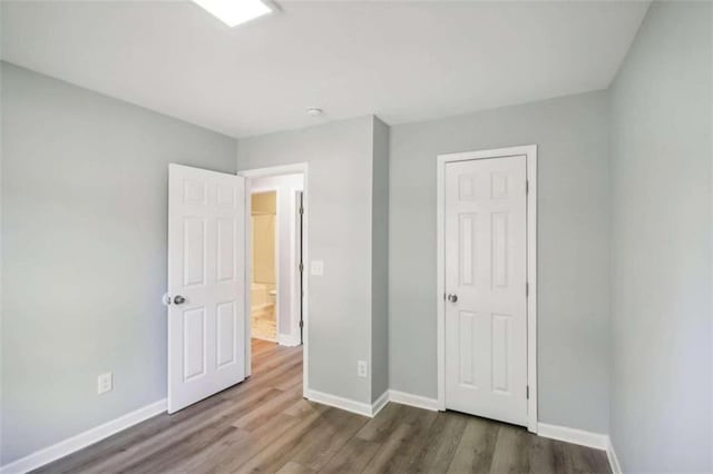 unfurnished bedroom with dark hardwood / wood-style floors and a closet