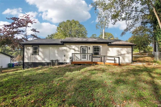 rear view of house featuring a yard, a deck, and cooling unit