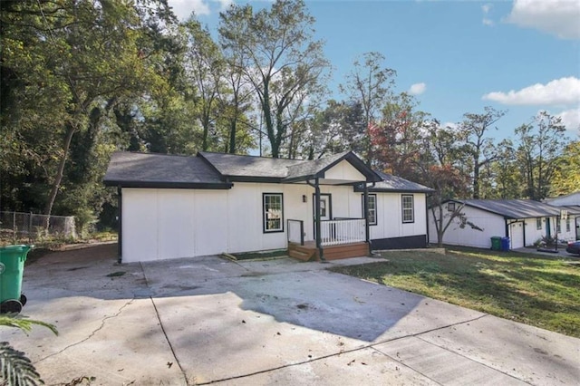 ranch-style home featuring a porch, a front yard, and a garage