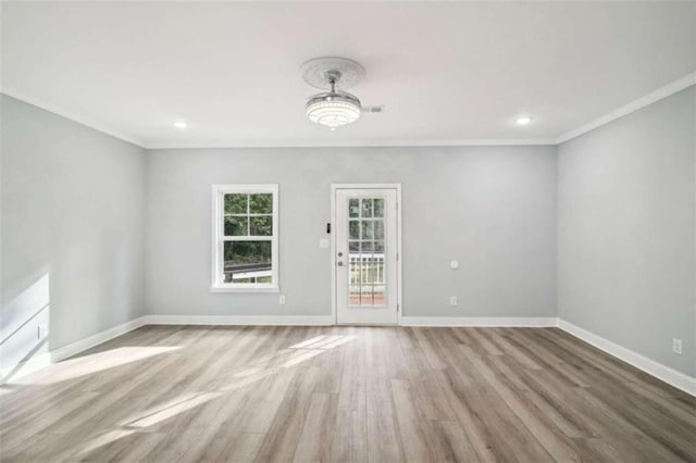 spare room featuring ornamental molding and light wood-type flooring