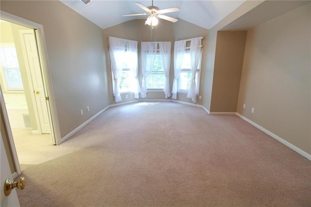 spare room with vaulted ceiling, carpet floors, and a ceiling fan
