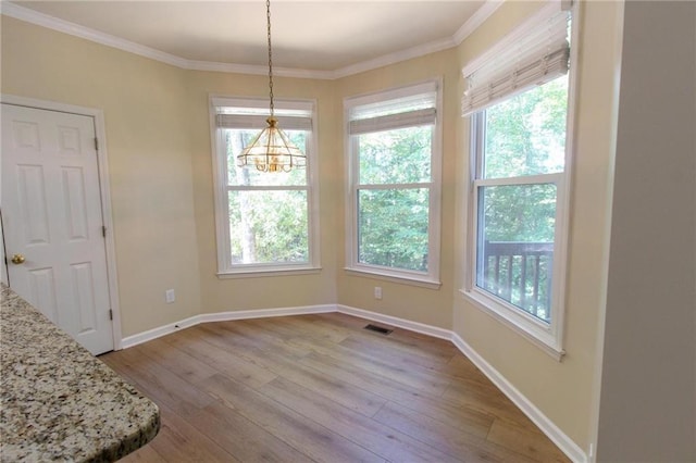 unfurnished dining area with plenty of natural light, visible vents, and hardwood / wood-style flooring