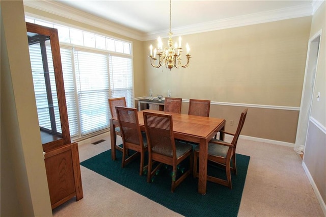carpeted dining room featuring an inviting chandelier, visible vents, baseboards, and crown molding