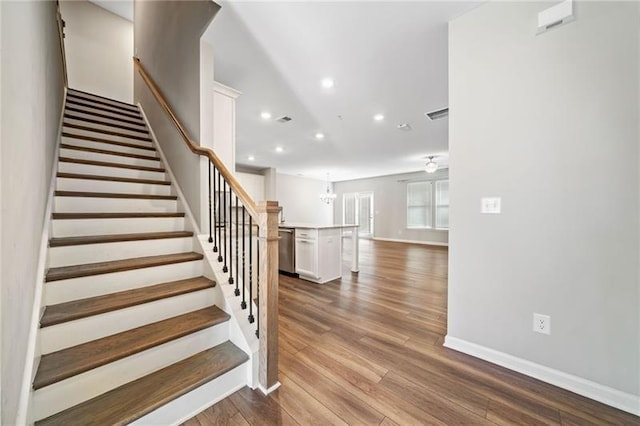 stairway with recessed lighting, wood finished floors, and baseboards