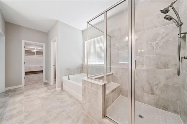 full bathroom featuring a shower stall, a garden tub, and a walk in closet