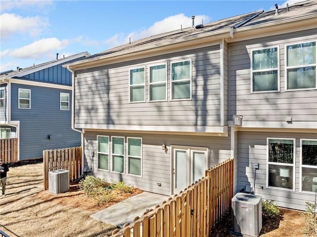 rear view of house featuring fence and central air condition unit