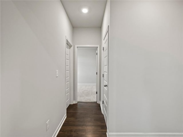 hallway featuring baseboards, recessed lighting, and dark wood-style floors