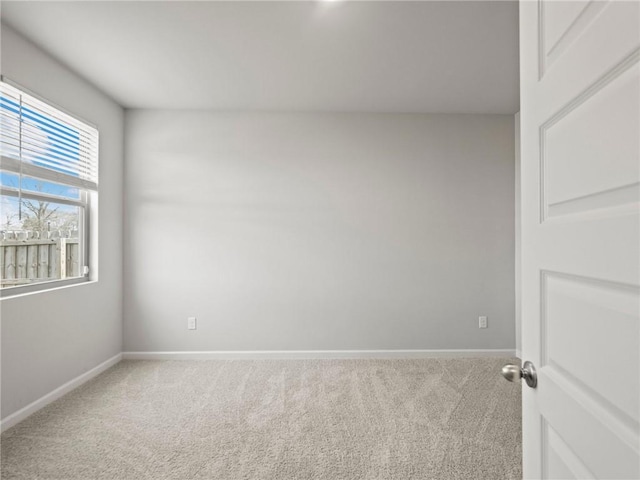 carpeted spare room featuring baseboards