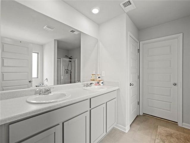 bathroom featuring visible vents, a sink, a shower stall, and double vanity