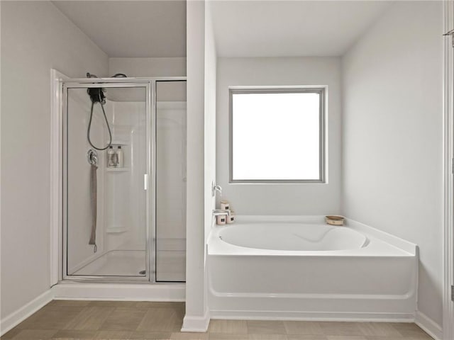 full bath featuring a garden tub, baseboards, and a stall shower