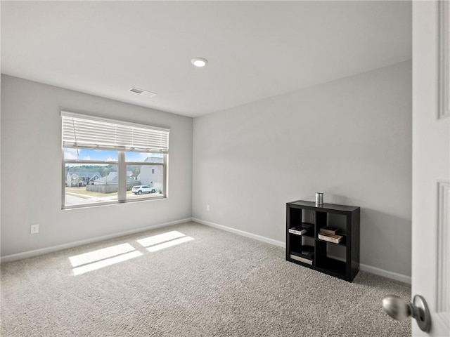 carpeted empty room with visible vents and baseboards