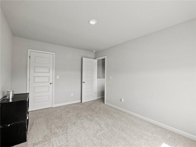 unfurnished bedroom with baseboards and carpet