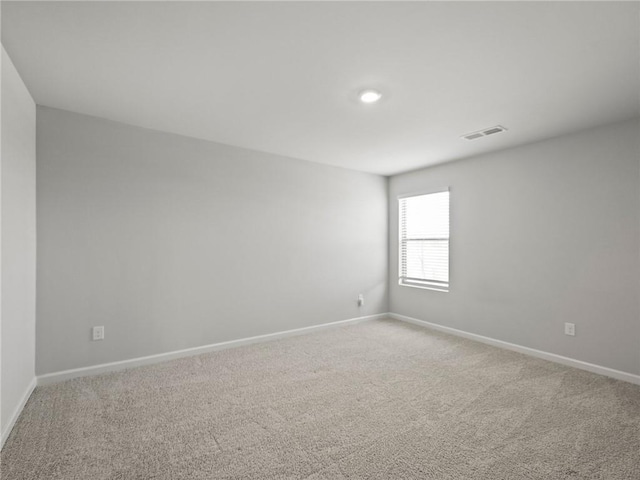 unfurnished room featuring baseboards, visible vents, and light carpet