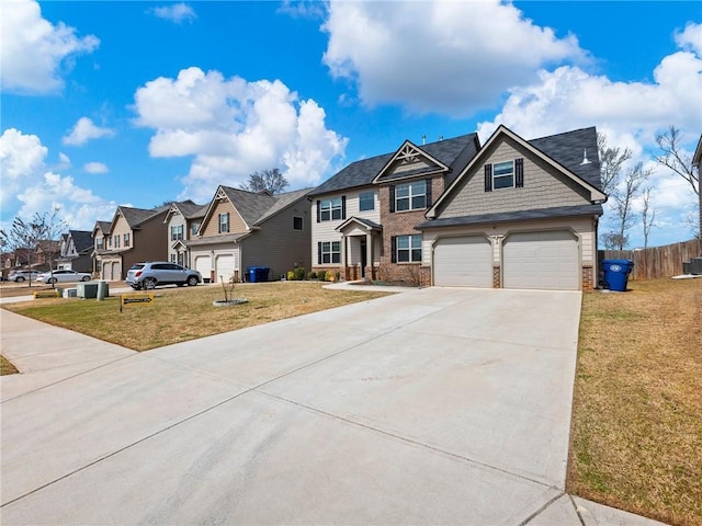 craftsman inspired home with driveway, fence, a front yard, brick siding, and a residential view