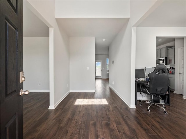 foyer featuring baseboards and dark wood-style floors