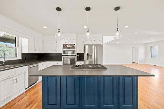 kitchen with a sink, dark countertops, tasteful backsplash, and stainless steel appliances