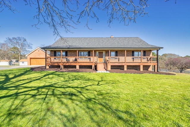 back of property with a yard, brick siding, and covered porch