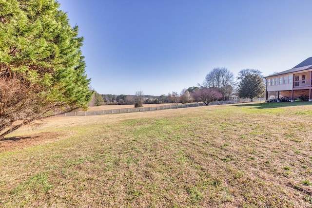 view of yard with a rural view and fence