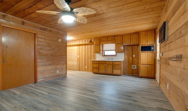 kitchen with ceiling fan, wood walls, wooden ceiling, and black microwave