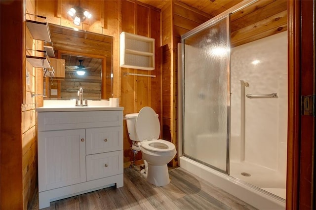 bathroom featuring vanity, hardwood / wood-style flooring, a shower with door, and wood walls