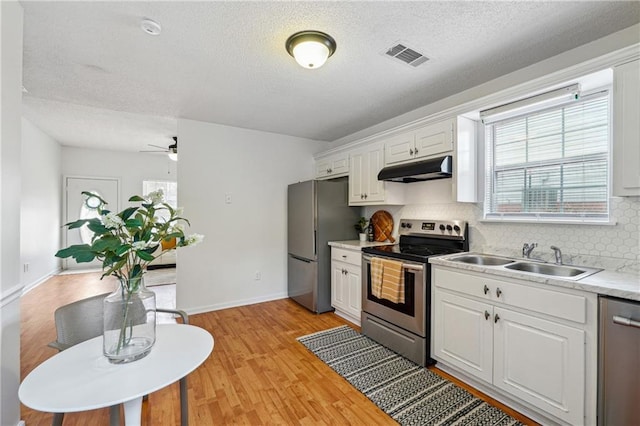 kitchen with sink, backsplash, stainless steel appliances, and white cabinets