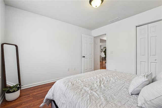 bedroom featuring dark wood-type flooring and a closet