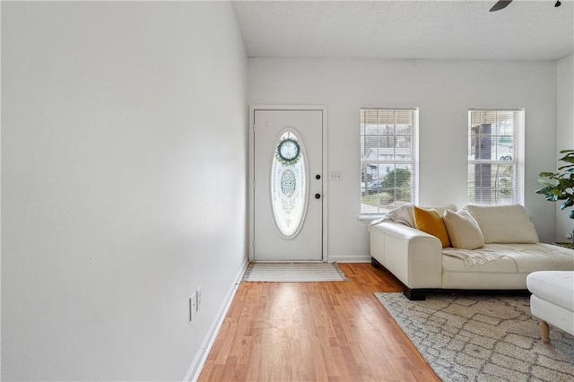 entryway with hardwood / wood-style flooring, ceiling fan, and a textured ceiling