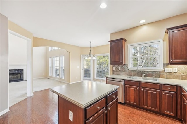 kitchen with a kitchen island, pendant lighting, tasteful backsplash, dishwasher, and sink