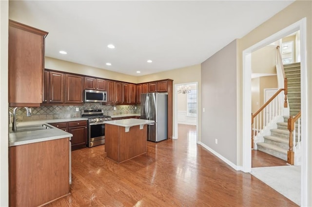 kitchen featuring a kitchen island, appliances with stainless steel finishes, tasteful backsplash, sink, and a kitchen breakfast bar