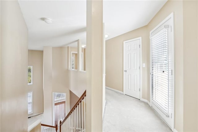 corridor featuring a healthy amount of sunlight and light carpet