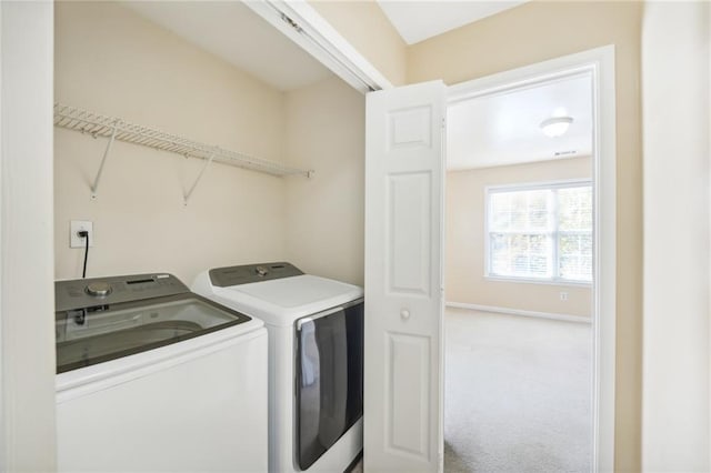 clothes washing area featuring washer and clothes dryer and carpet flooring