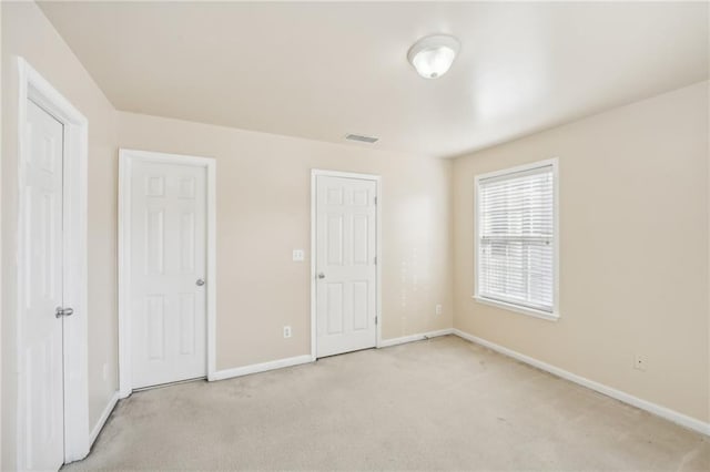 unfurnished bedroom featuring light carpet