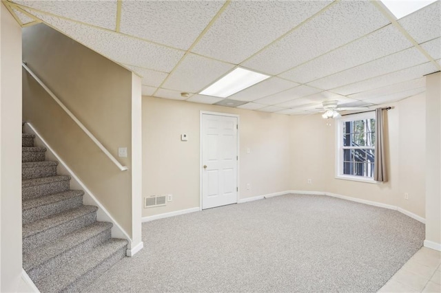 basement with light carpet and a paneled ceiling