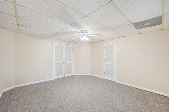 carpeted empty room featuring a paneled ceiling and ceiling fan