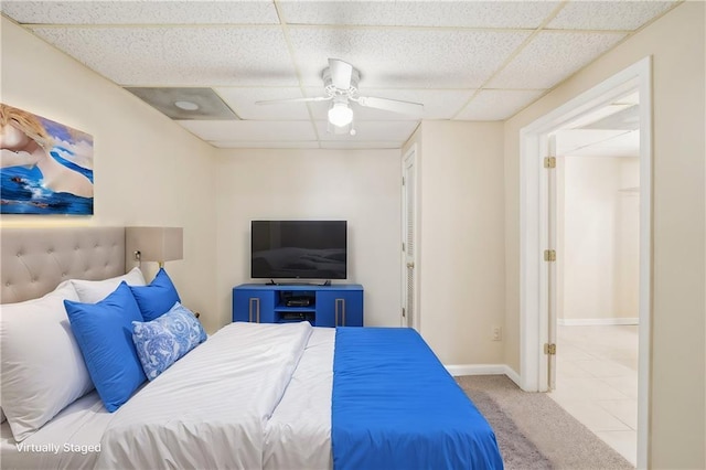 carpeted bedroom with a drop ceiling and ceiling fan