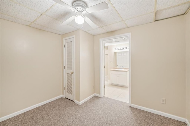 spare room with a paneled ceiling, light carpet, and ceiling fan