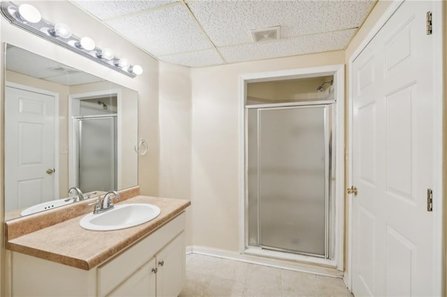 bathroom with vanity, a paneled ceiling, and walk in shower